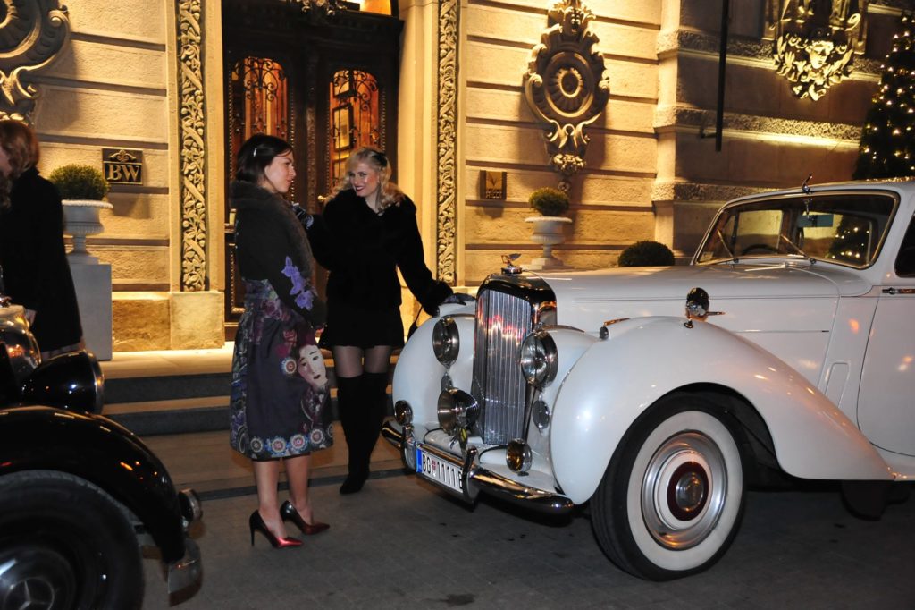 Devojke pored starinskih automobila pred početak događaja